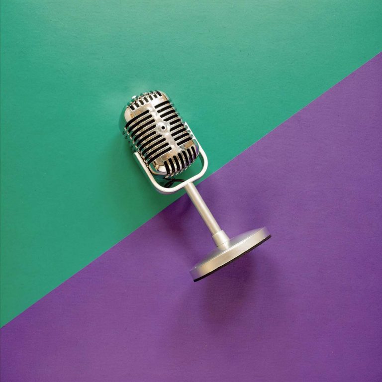 Vintage microphone against the purple and mint green podcast colour palette.